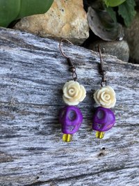 Purple skulls  with a beautiful  delicate resin fower and glass yellow accent  bead 