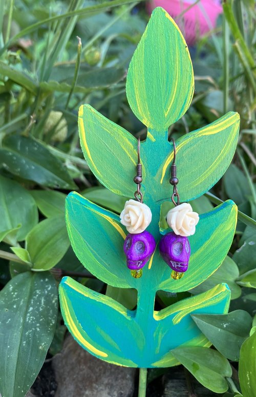 Purple skulls  with a beautiful  delicate resin fower and glass yellow accent  bead 