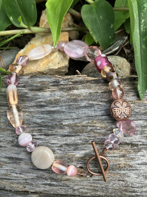 Hand beaded Bracelet  lamp work pink and cats eye dichroic and  neutral toned glass and crystal beads with a butterfly button copper bead copper toggle clasp 