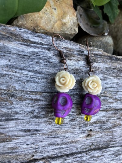 Purple skulls  with a beautiful  delicate resin fower and glass yellow accent  bead 