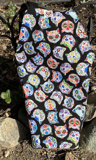 Handmade coffin bag by Lucky Burrito with cat skeletons on black fabric with coordinating blue fabric